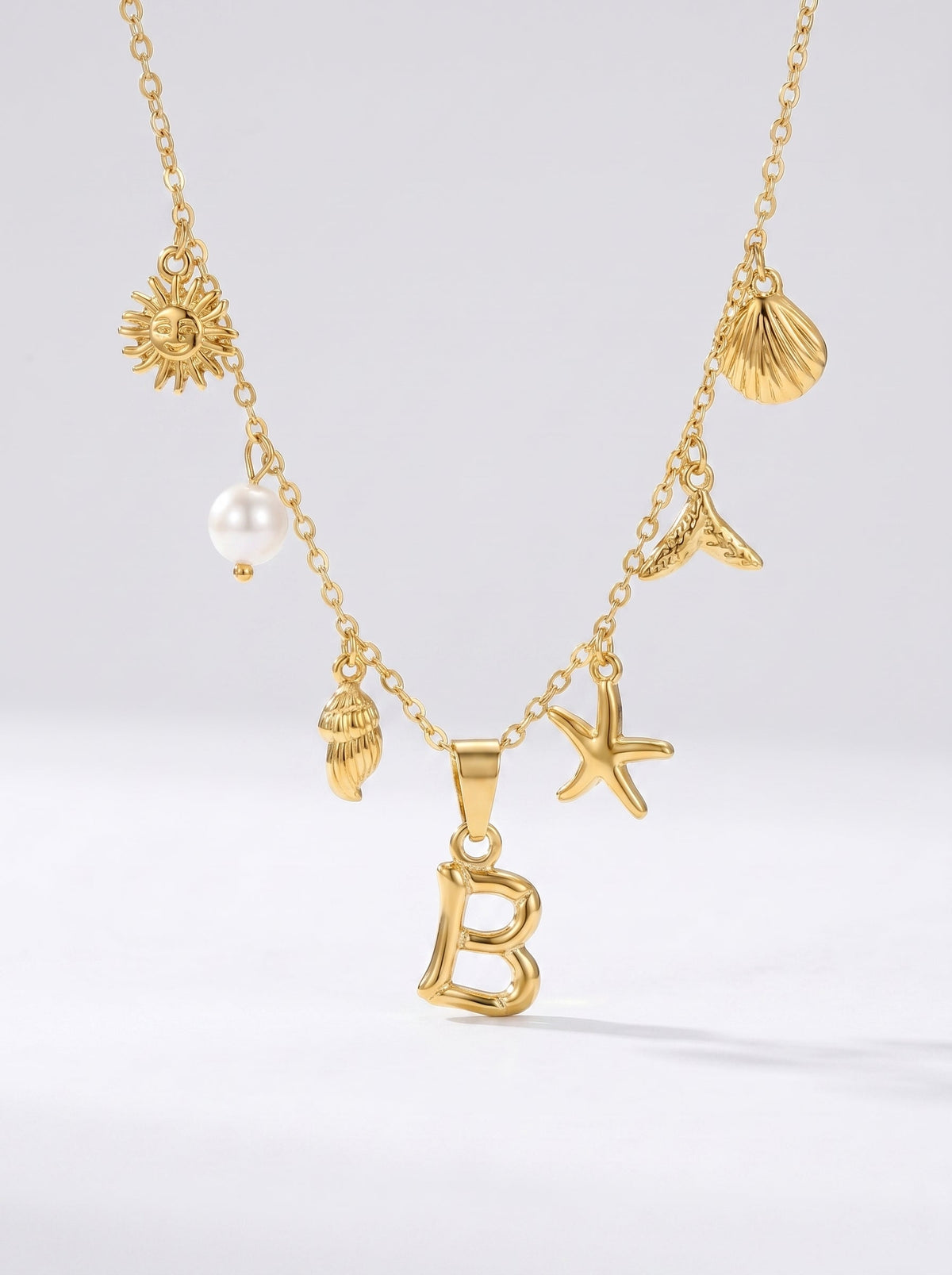 Collar dorado del mar con letra inicial B, estrella de mar, conchas, perla y colgante de sol.