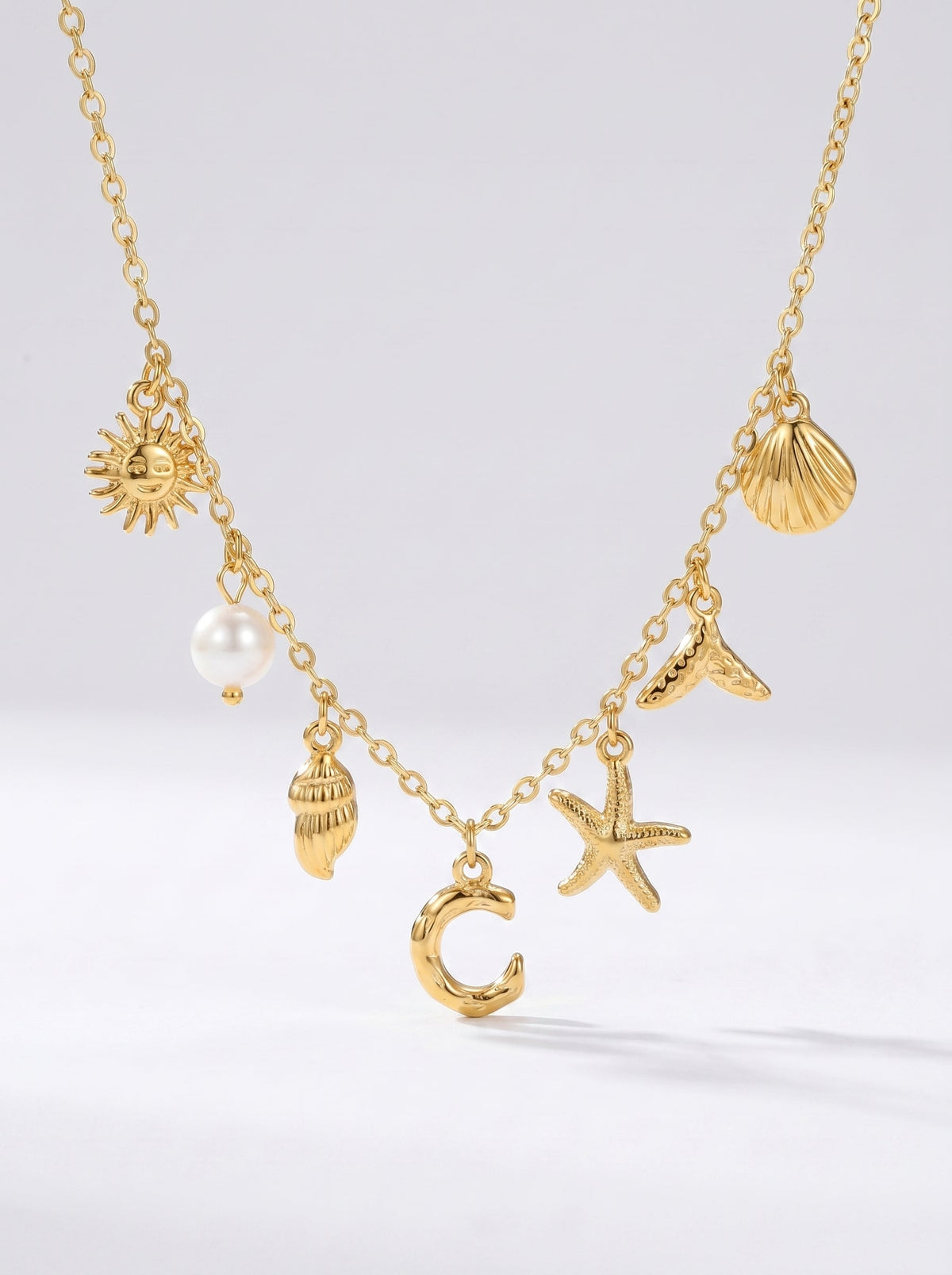 Collar dorado del mar con letra inicial C, estrella de mar, conchas, perla y colgante de sol.