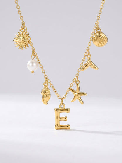 Collar dorado del mar con letra inicial E, estrella de mar, conchas, perla y colgante de sol.