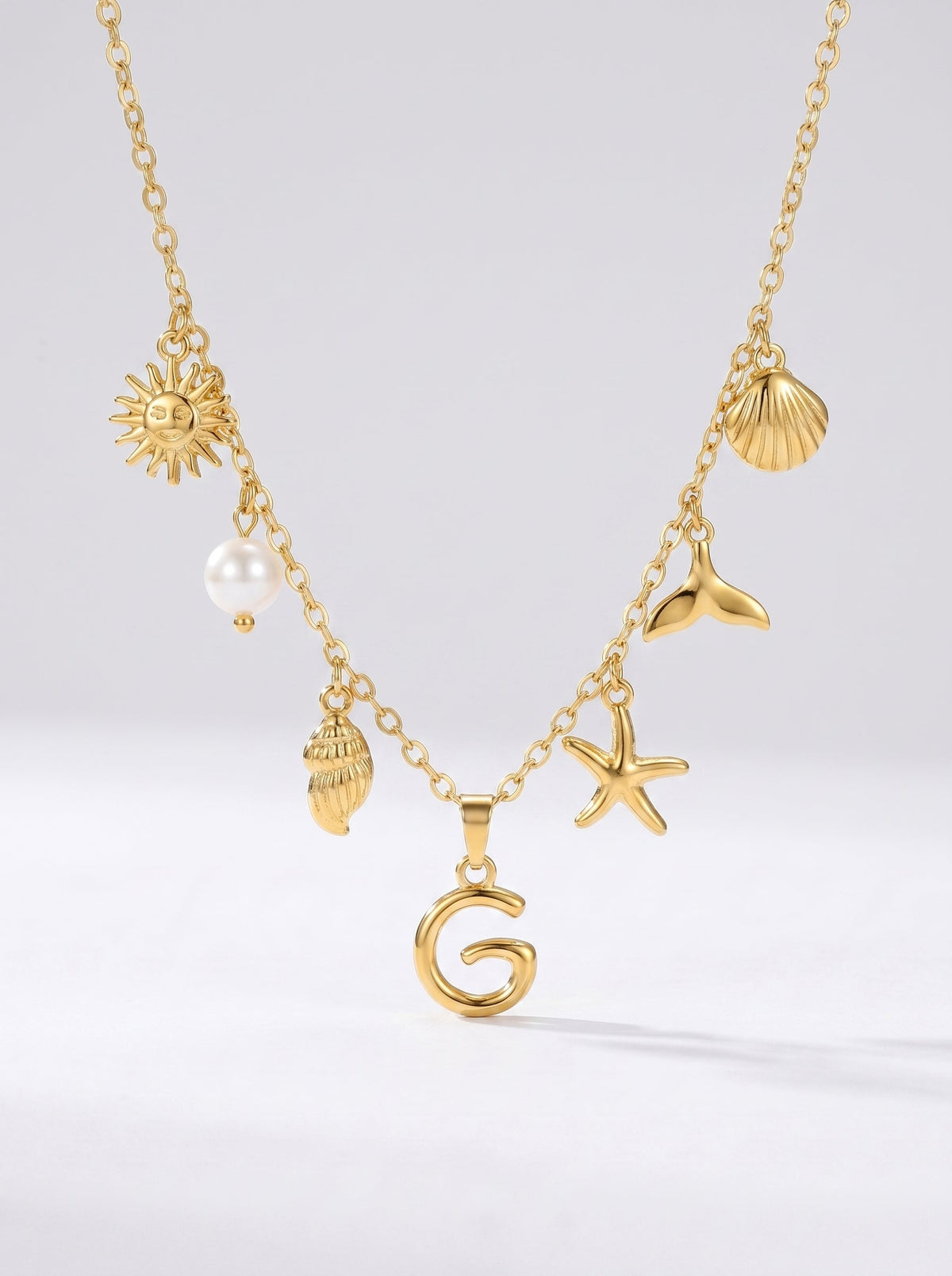 Collar dorado del mar con letra inicial G, estrella de mar, conchas, perla y colgante de sol.