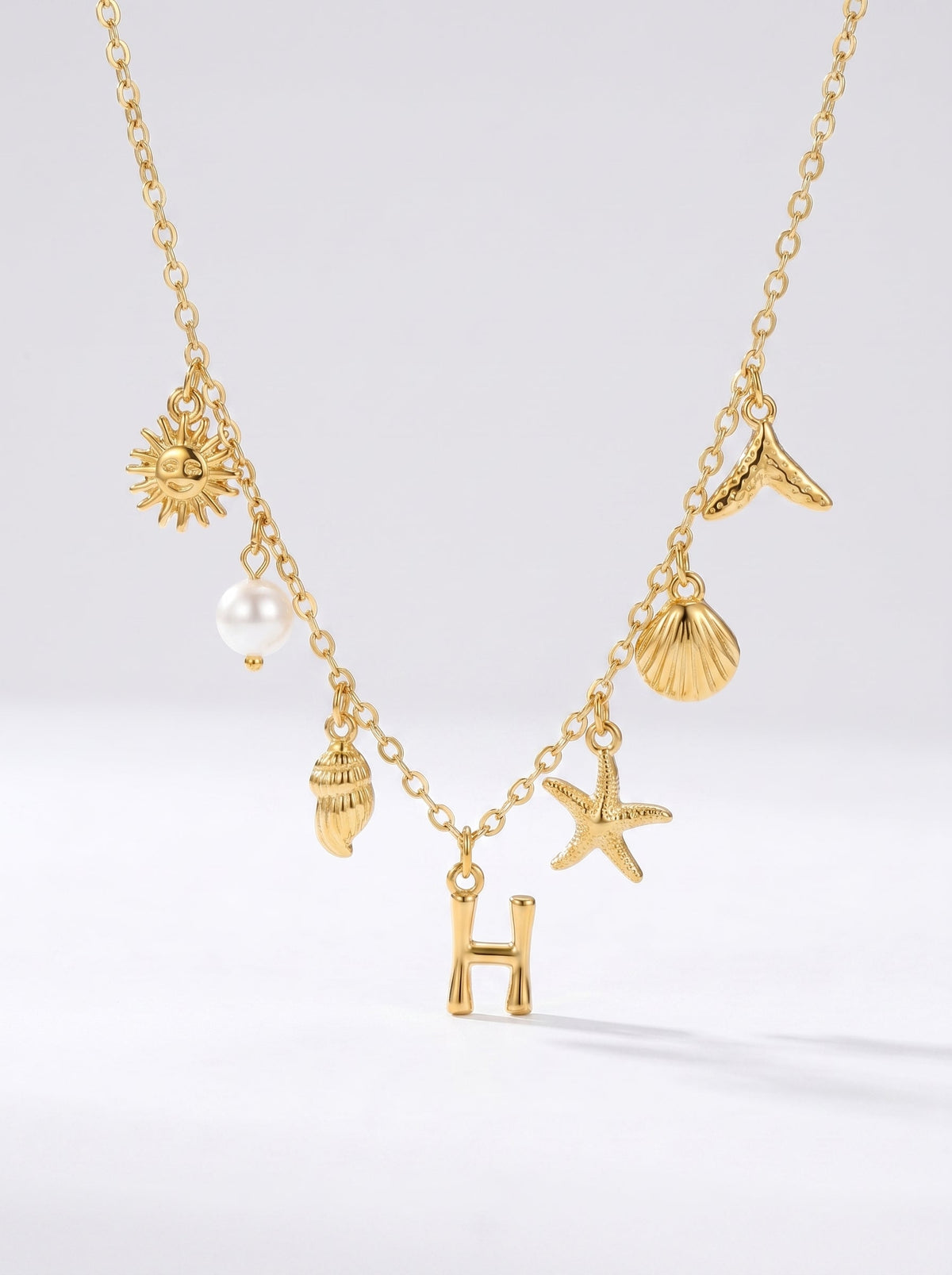 Collar dorado del mar con letra inicial H, estrella de mar, conchas, perla y colgante de sol.