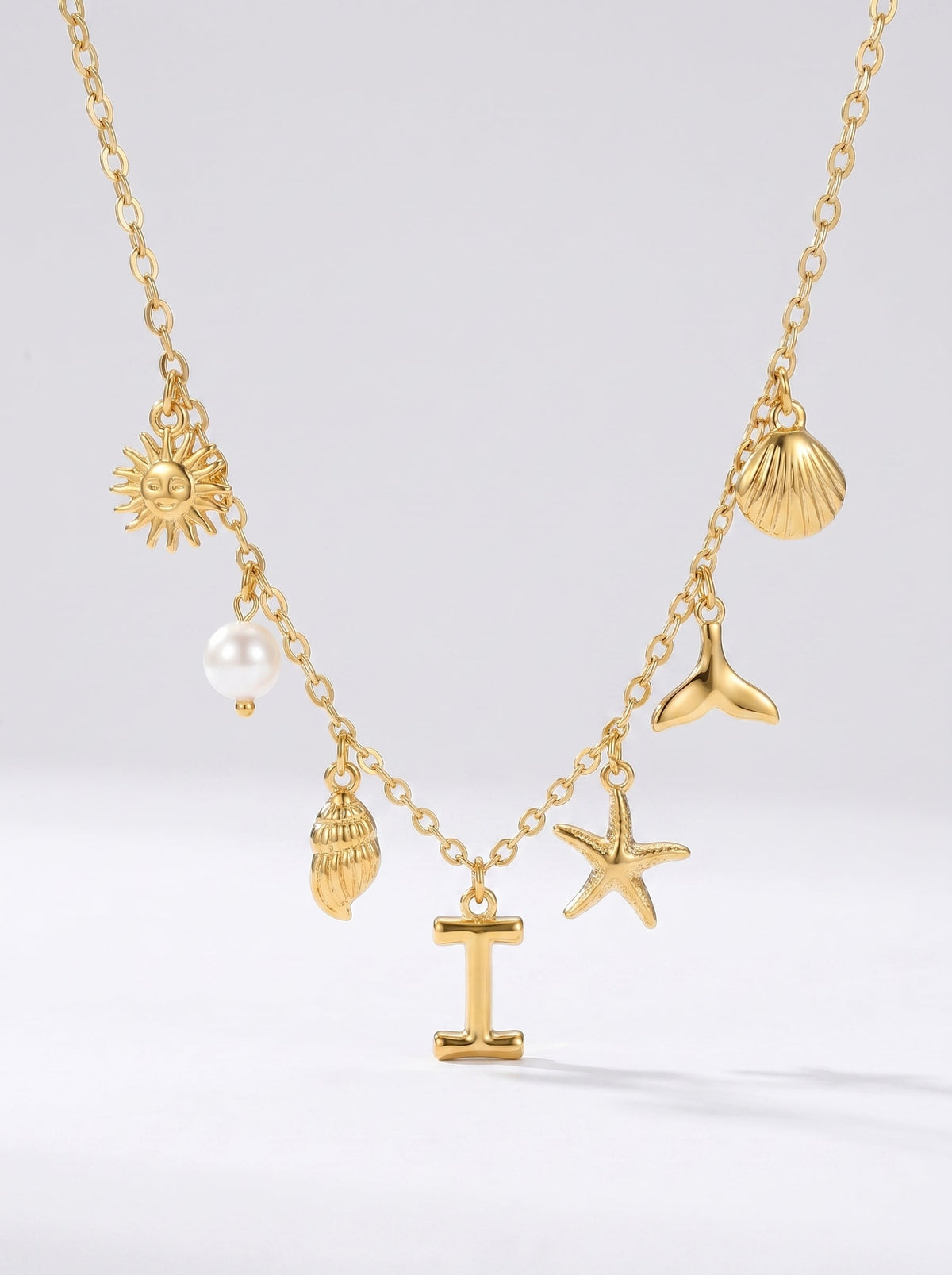 Collar dorado del mar con letra inicial I, estrella de mar, conchas, perla y colgante de sol.