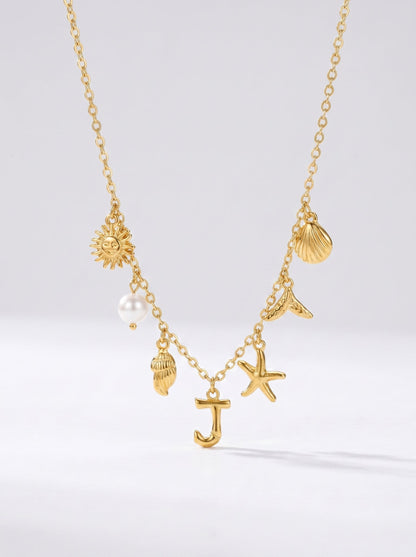 Collar dorado del mar con letra inicial J, estrella de mar, conchas, perla y colgante de sol.