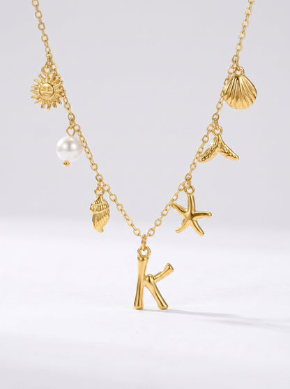 Collar dorado del mar con letra inicial K, estrella de mar, conchas, perla y colgante de sol.