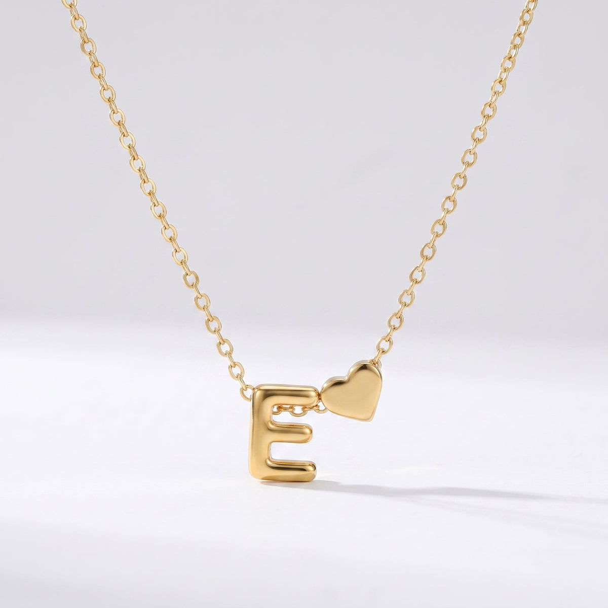 Collar letra E dorado con corazón, collar personalizado femenino en acero inoxidable resistente al agua.
