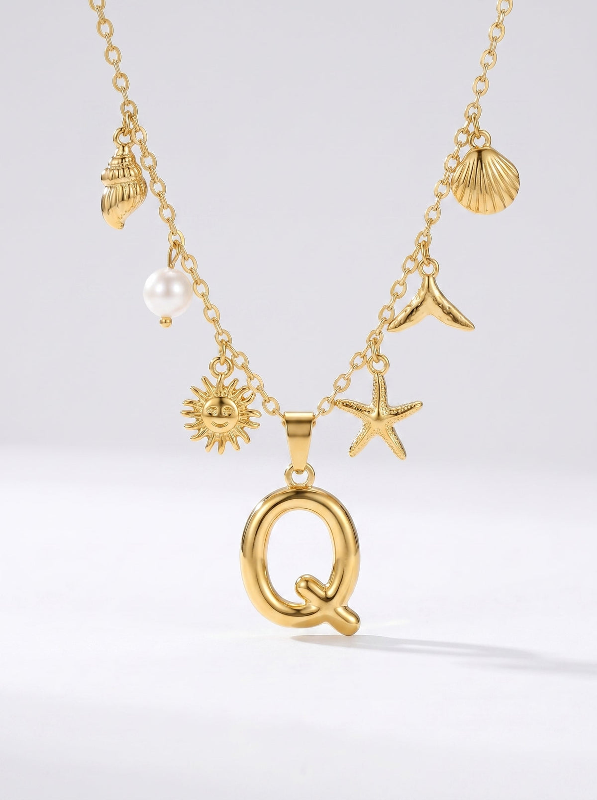 Collar dorado del mar con letra inicial Q, estrella de mar, conchas, perla y colgante de sol.
