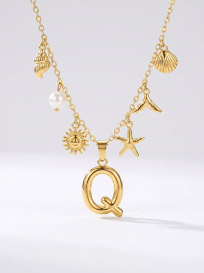 Collar dorado del mar con letra inicial Q, estrella de mar, conchas, perla y colgante de sol.