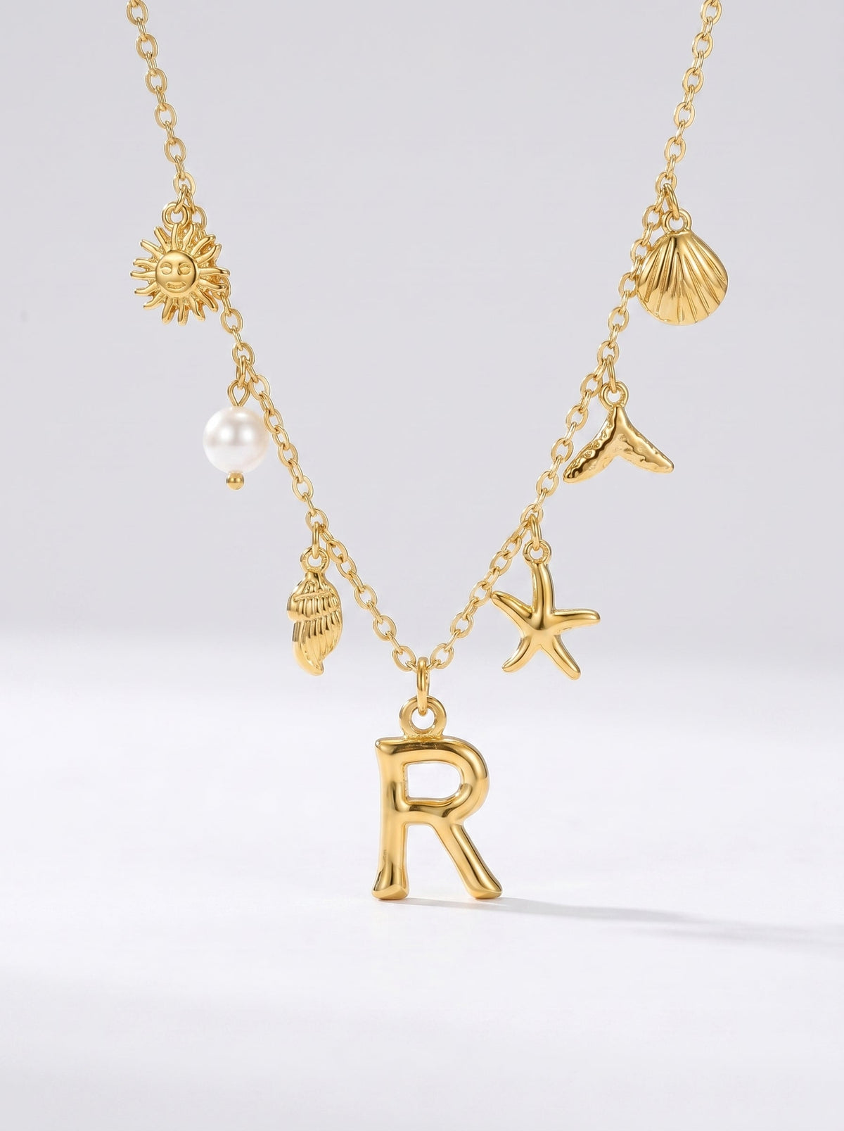 Collar dorado del mar con letra inicial R, estrella de mar, conchas, perla y colgante de sol.