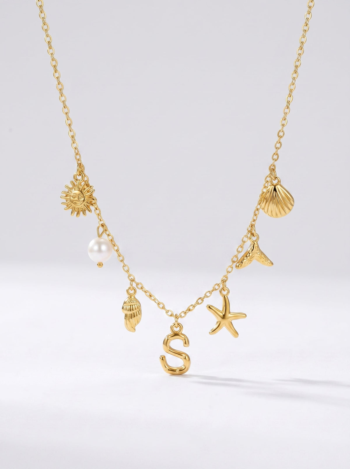 Collar dorado del mar con letra inicial S, estrella de mar, conchas, perla y colgante de sol.