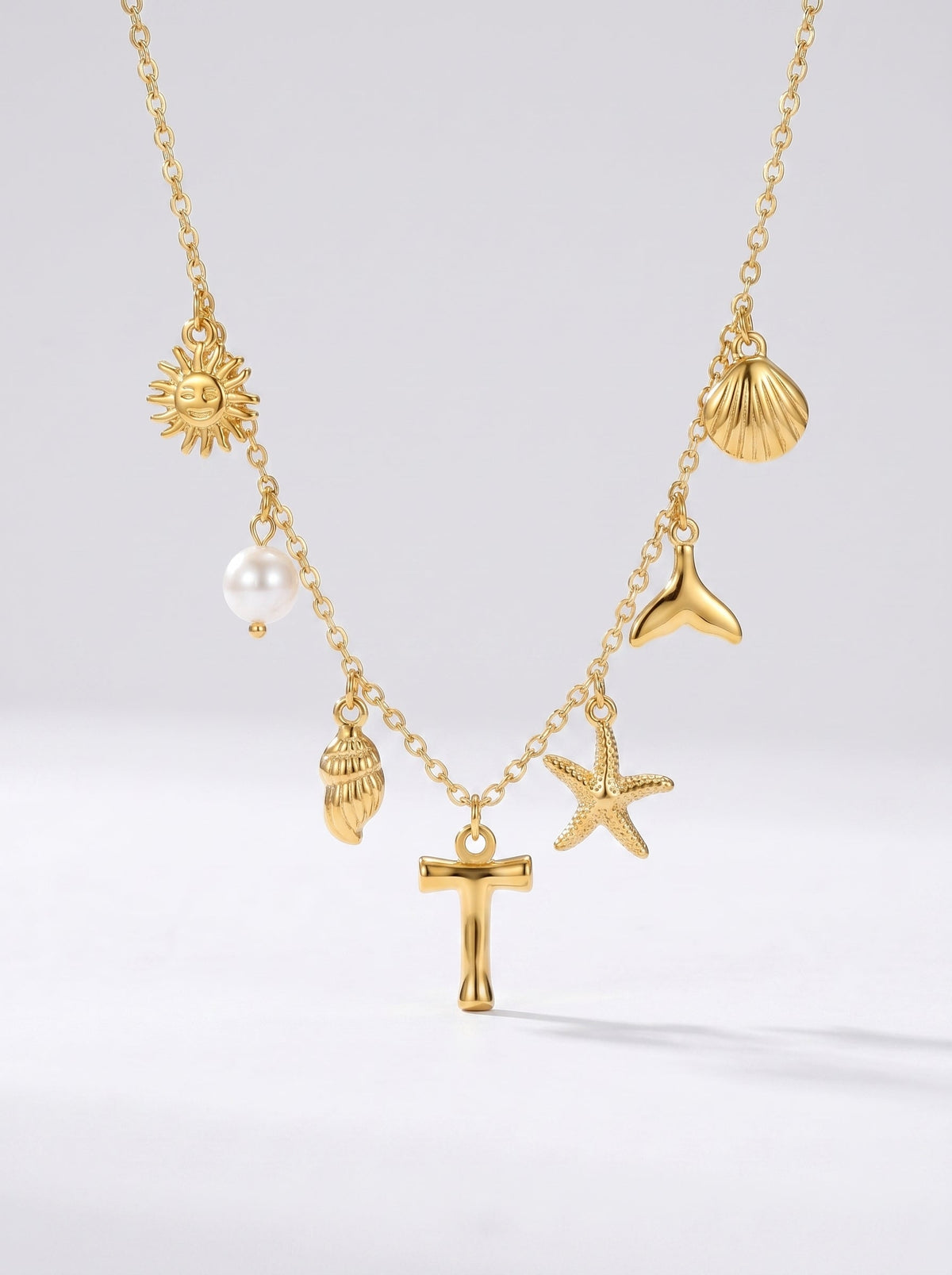 Collar dorado del mar con letra inicial T, estrella de mar, conchas, perla y colgante de sol.