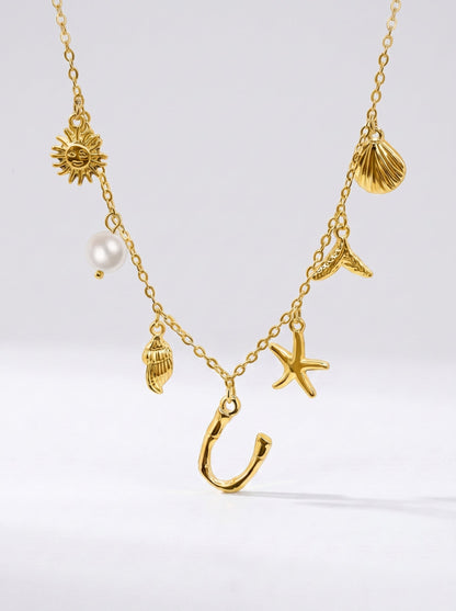 Collar dorado del mar con letra inicial U, estrella de mar, conchas, perla y colgante de sol.