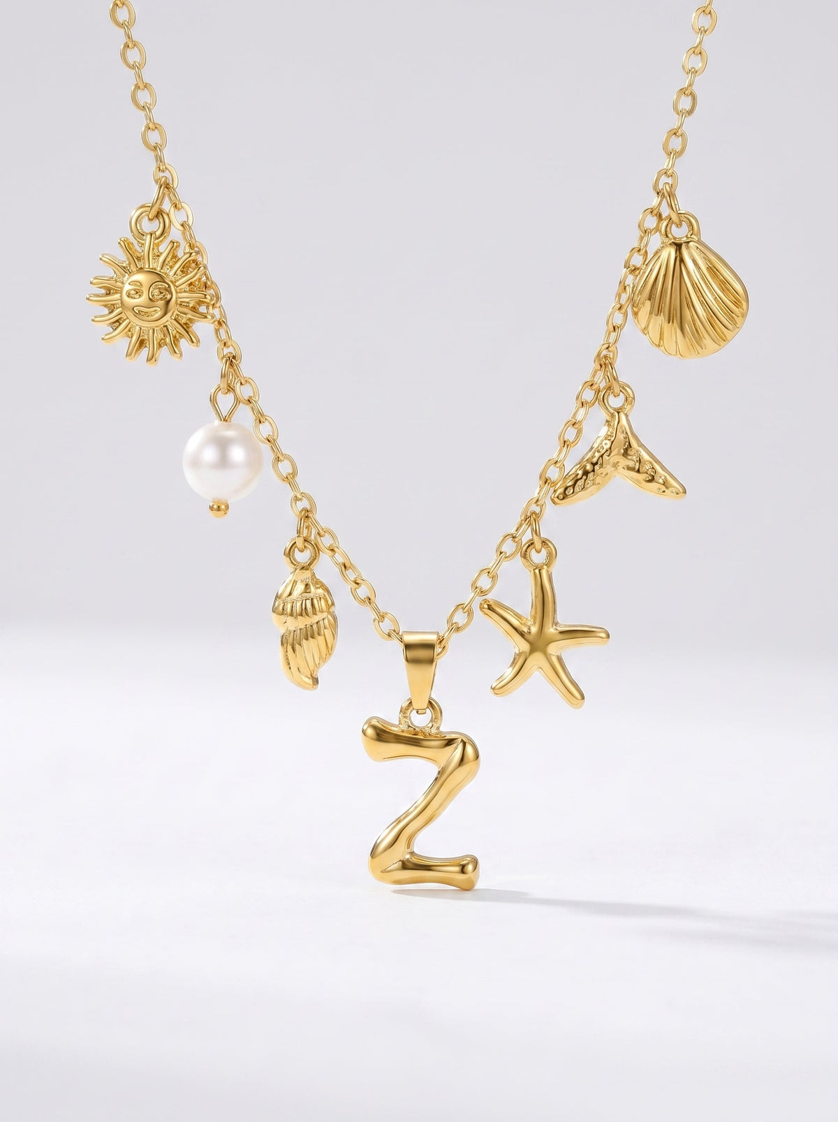 Collar dorado del mar con letra inicial Z, estrella de mar, conchas, perla y colgante de sol.