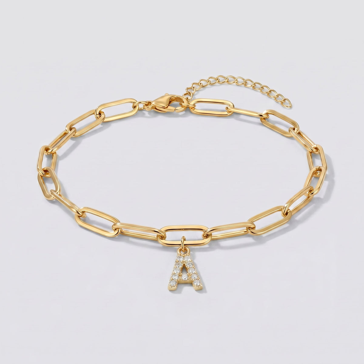 Pulsera dorada con letra inicial A, cadena paperclip y colgante de letra engastado.