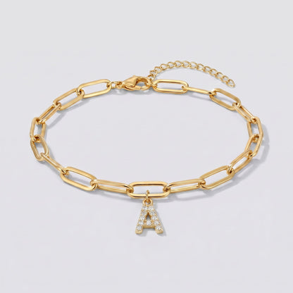 Pulsera dorada con letra inicial A, cadena paperclip y colgante de letra engastado.