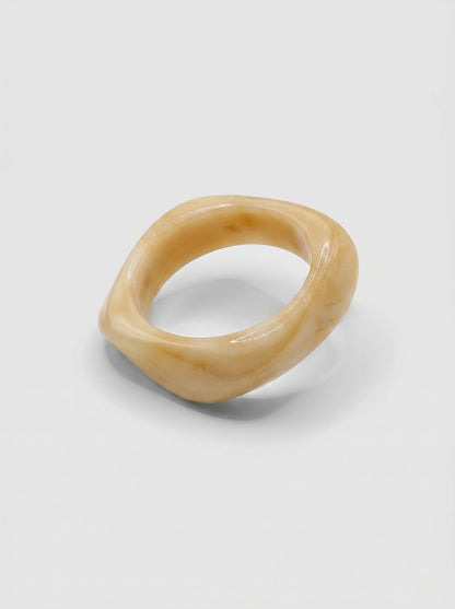 Pulsera Vainilla en resina marmoleada en tonos vainilla y crema, con diseño orgánico geométrico y acabado brillante, ideal para un look elegante y contemporáneo.