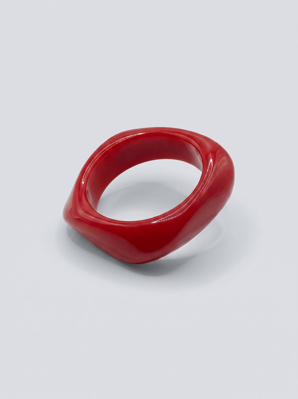 Pulsera Cereza en resina marmoleada en tonos cereza y rojo profundo, con diseño orgánico geométrico y acabado brillante, ideal para un look elegante y contemporáneo.
