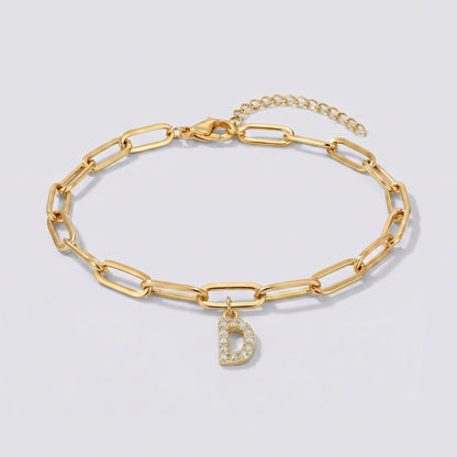 Pulsera dorada con letra inicial D, cadena paperclip y colgante de letra engastado.
