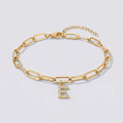 Pulsera dorada con letra inicial E, cadena paperclip y colgante de letra engastado.