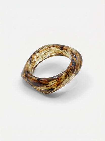 Pulsera de resina marrón marmoleada, con forma rectangular y acabado brillante.