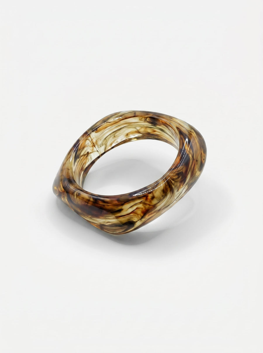 Pulsera de resina marrón marmoleada, con forma rectangular y acabado brillante.