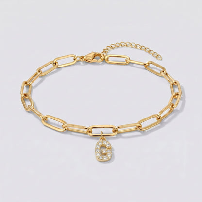 Pulsera dorada con letra inicial G, cadena paperclip y colgante de letra engastado.
