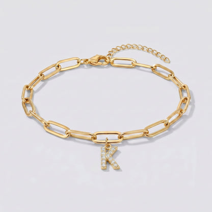Pulsera dorada con letra inicial K, cadena paperclip y colgante de letra engastado.