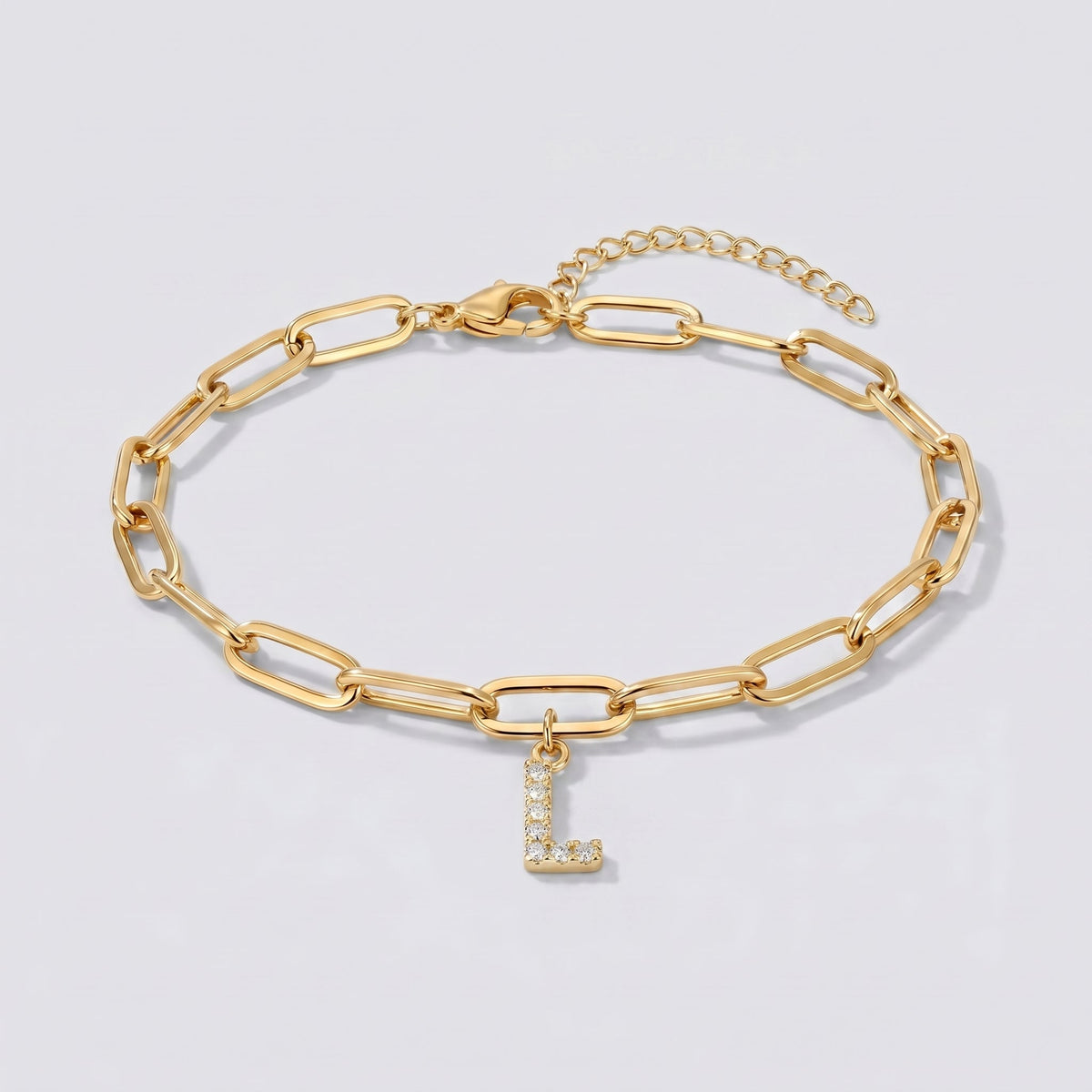 Pulsera dorada con letra inicial L, cadena paperclip y colgante de letra engastado.