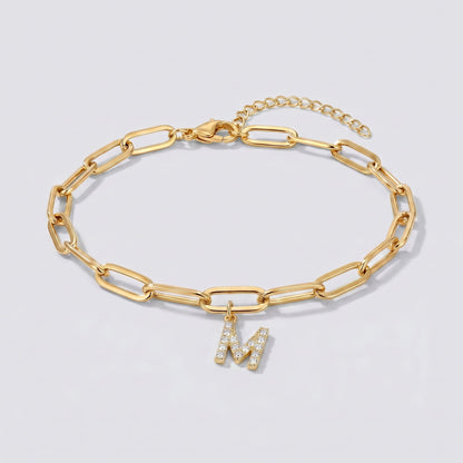 Pulsera dorada con letra inicial M, cadena paperclip y colgante de letra engastado.