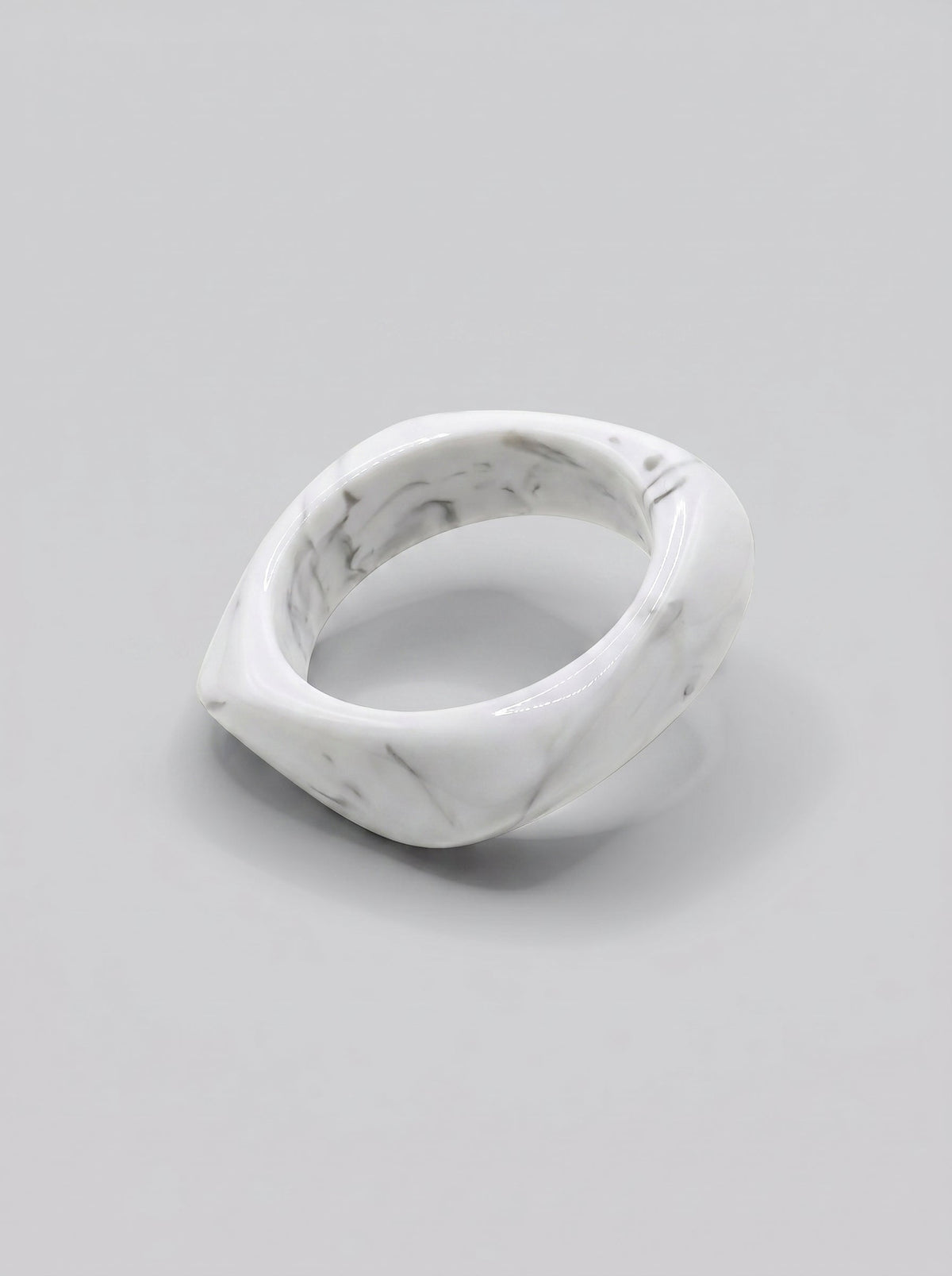 Pulsera Mármol en resina marmoleada en tonos mármol blanco y gris, con diseño orgánico geométrico y acabado brillante, ideal para un look elegante y contemporáneo.
