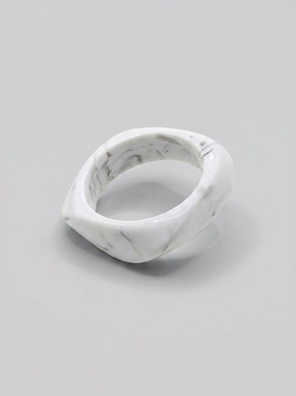 Pulsera Mármol en resina marmoleada en tonos mármol blanco y gris, con diseño orgánico geométrico y acabado brillante, ideal para un look elegante y contemporáneo.
