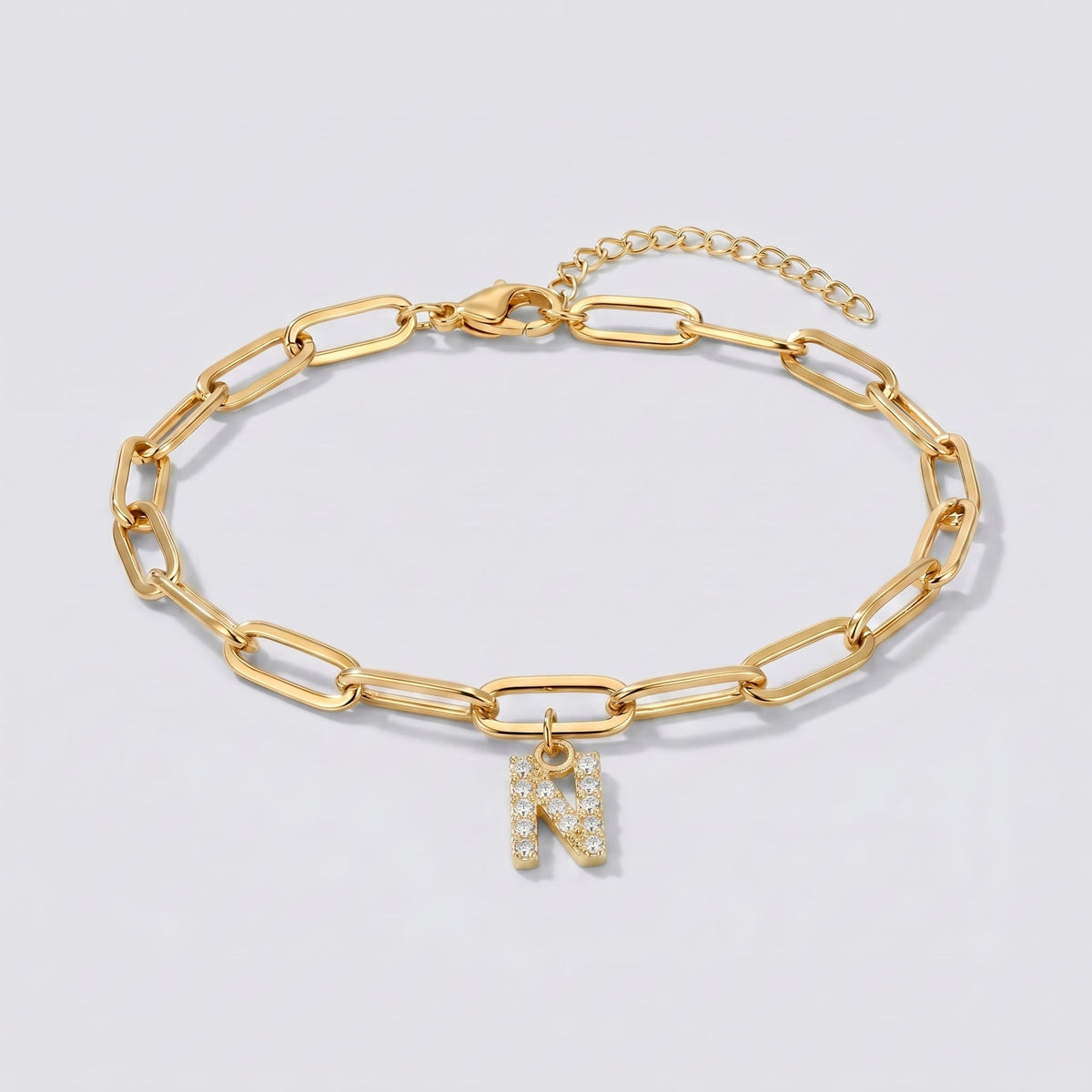 Pulsera dorada con letra inicial N, cadena paperclip y colgante de letra engastado.