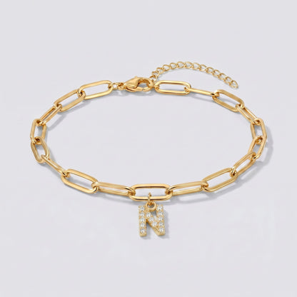 Pulsera dorada con letra inicial N, cadena paperclip y colgante de letra engastado.