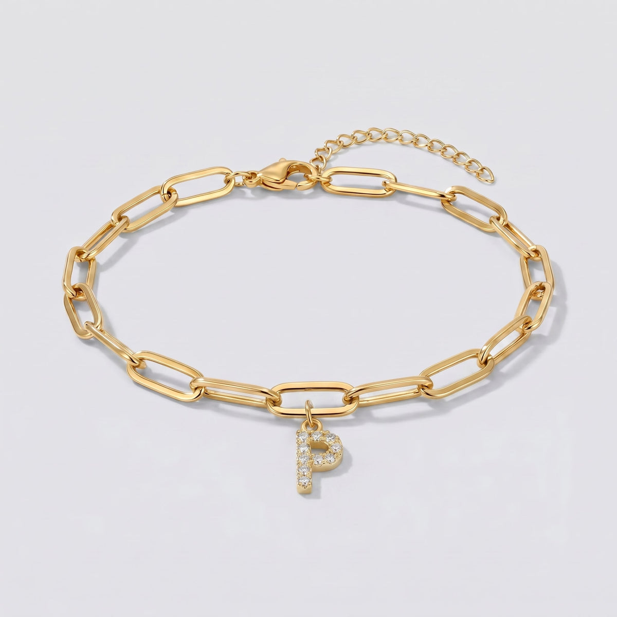Pulsera dorada con letra inicial P, cadena paperclip y colgante de letra engastado.