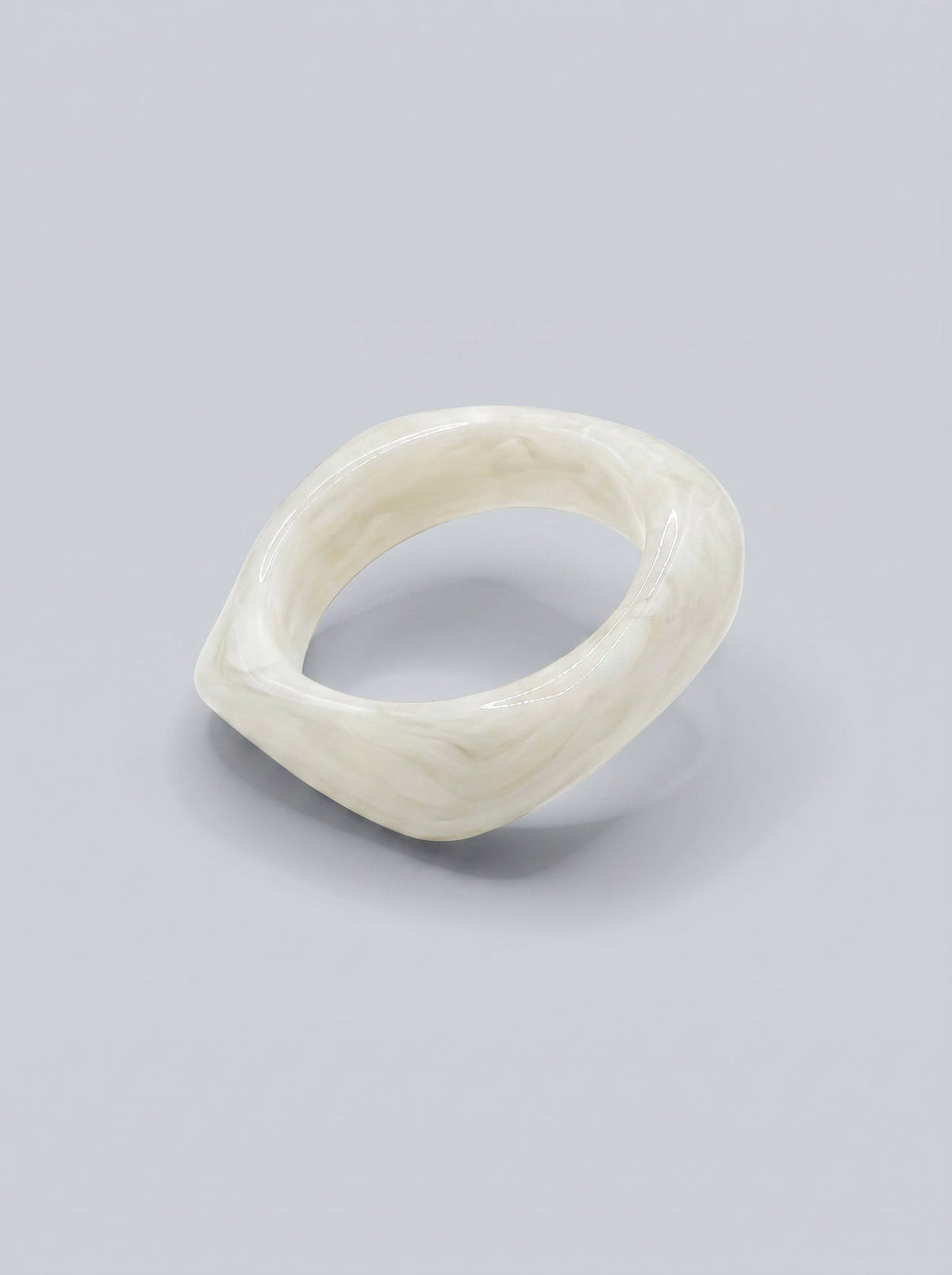 Pulsera Perla en resina marmoleada blanca, con diseño orgánico geométrico y acabado brillante, ideal para un look elegante y contemporáneo.