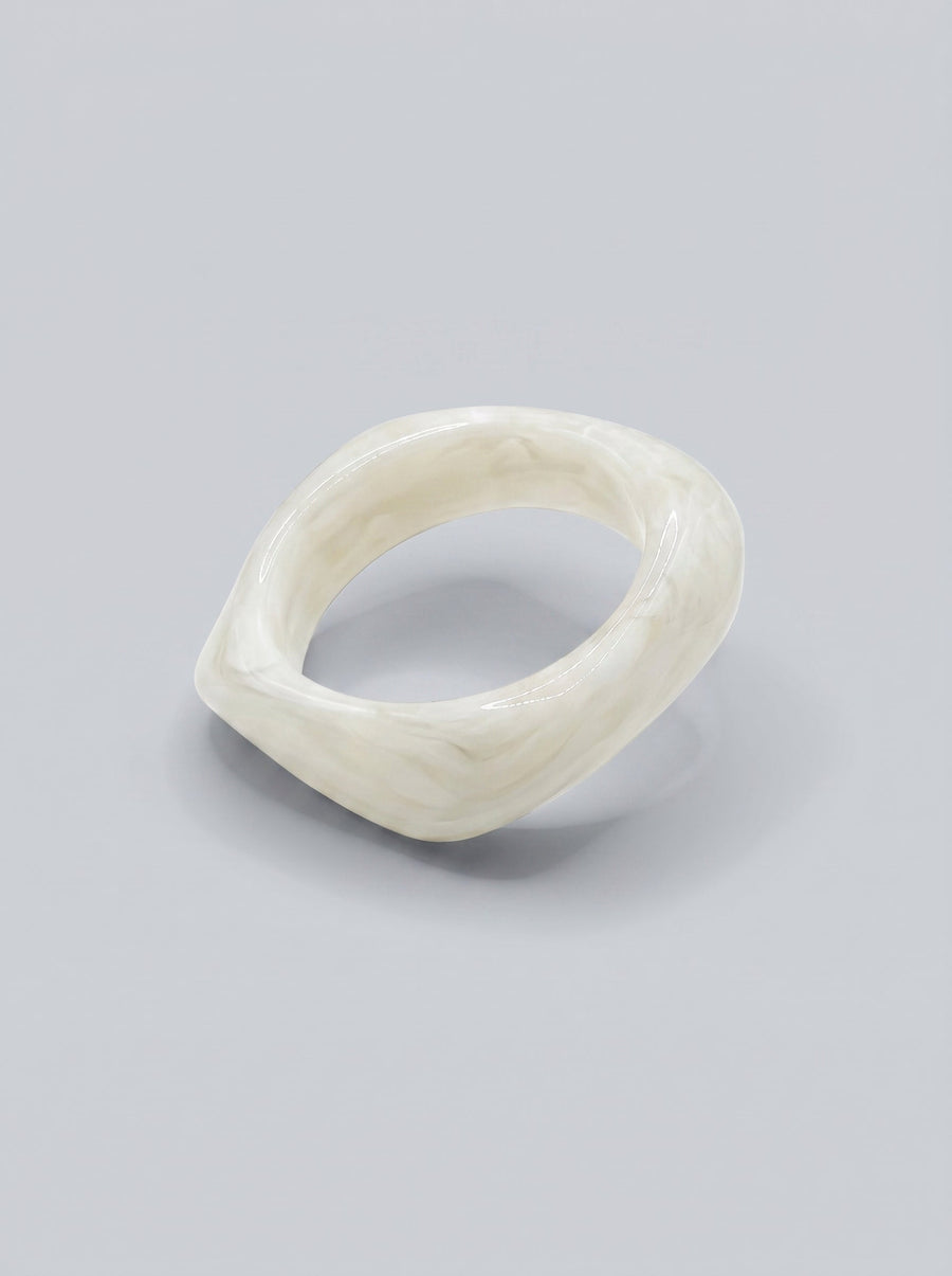 Pulsera Perla en resina marmoleada blanca, con diseño orgánico geométrico y acabado brillante, ideal para un look elegante y contemporáneo.