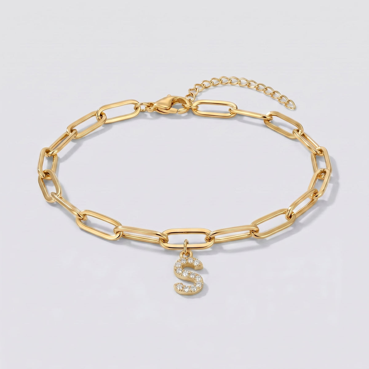Pulsera dorada con letra inicial S, cadena paperclip y colgante de letra engastado.