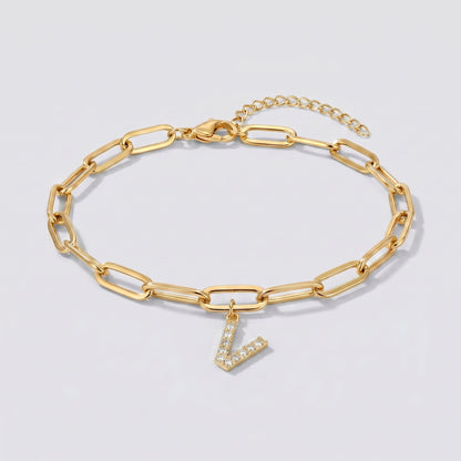 Pulsera dorada con letra inicial V, cadena paperclip y colgante de letra engastado.