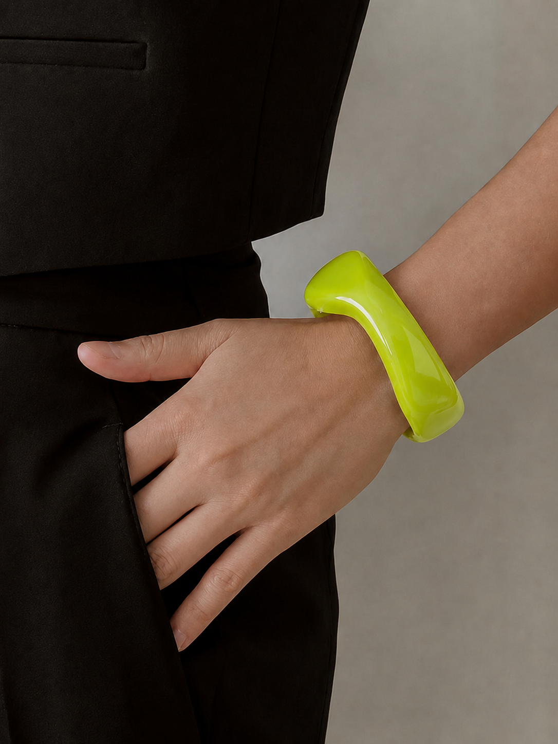 Pulsera de resina verde lima usada en la muñeca, con acabado brillante y estilo elegante.