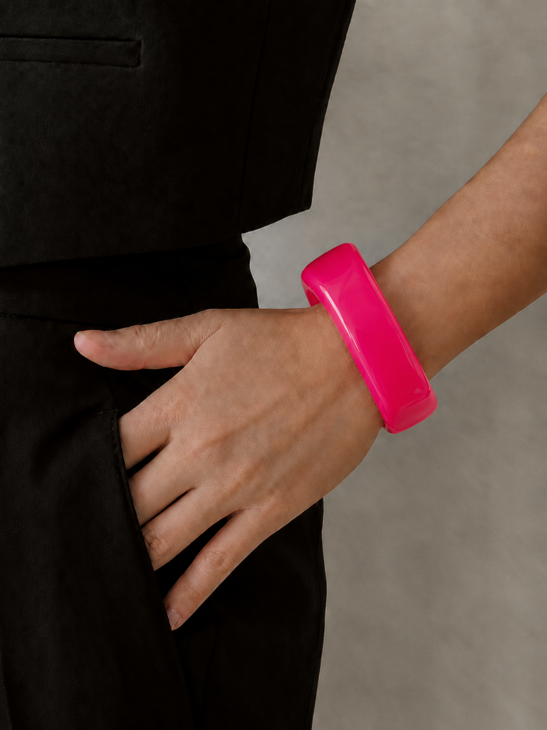 Pulsera de resina rosa pitaya en la muñeca, con acabado brillante y estilo elegante.