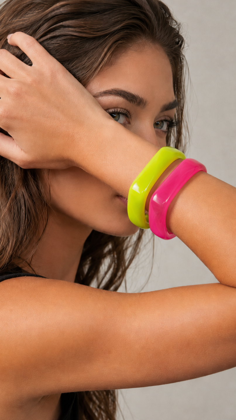 Pulseras de resina verde lima y rosa usadas por una modelo, con acabado brillante y estilo elegante.