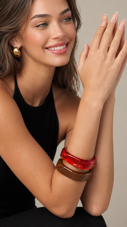 Pulseras de resina roja y marrón usadas por una modelo, con acabado brillante y estilo elegante.
