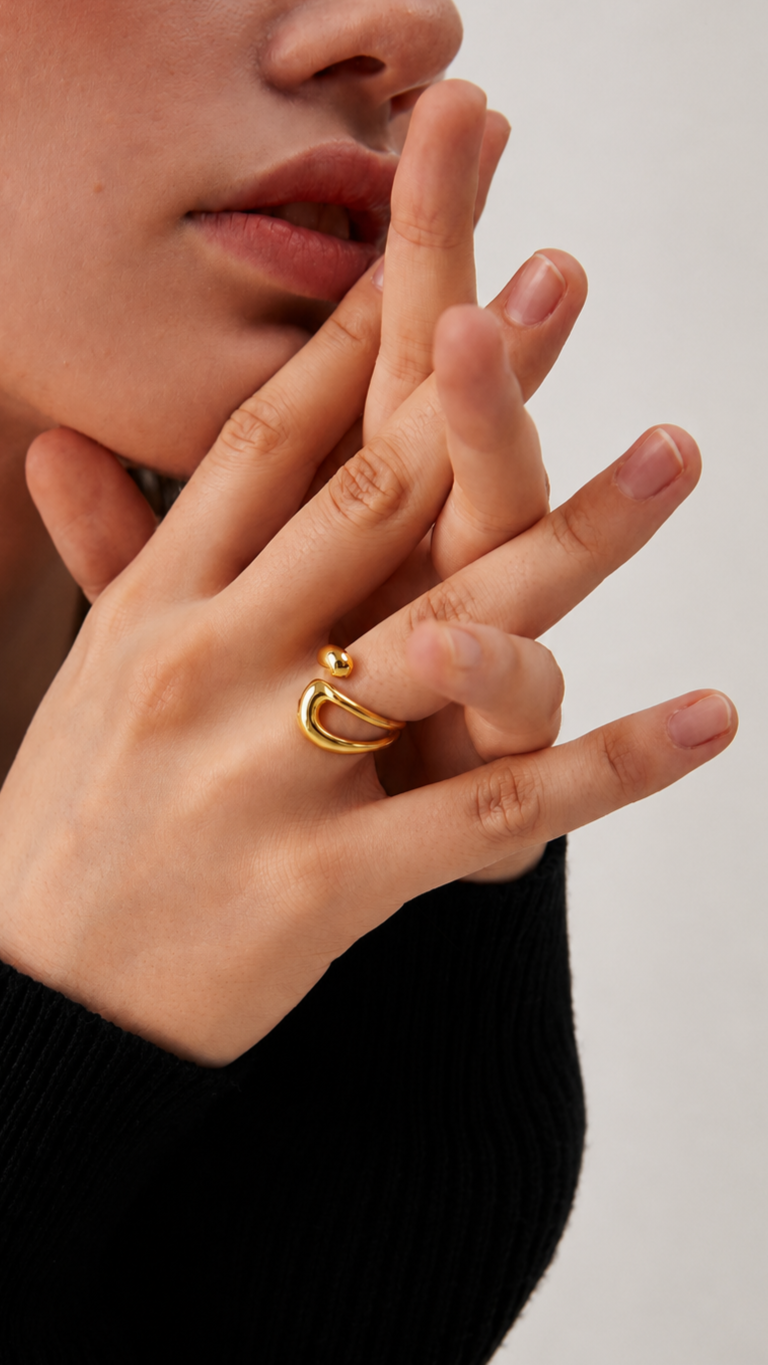 Anillo dorado moderno con diseño orgánico llevado por una modelo en primer plano elegante.