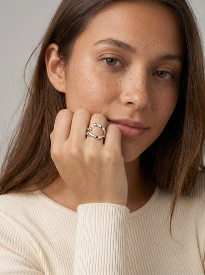 Mujer con un anillo sobre un fondo neutro
