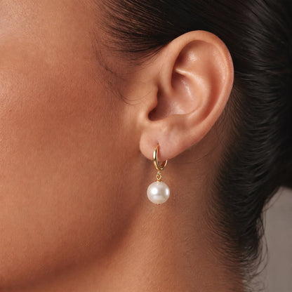 Pendientes aro con perla dorados en uso — primer plano en la oreja