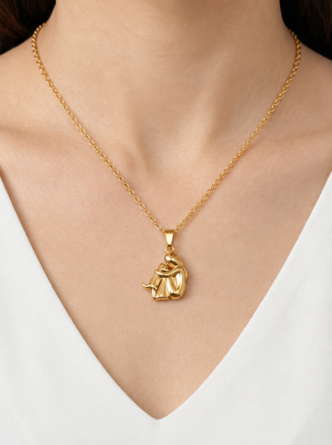 Collar dorado delicado con colgante artístico abstracto y acabado brillante, usado al cuello para un look moderno, elegante y sofisticado.