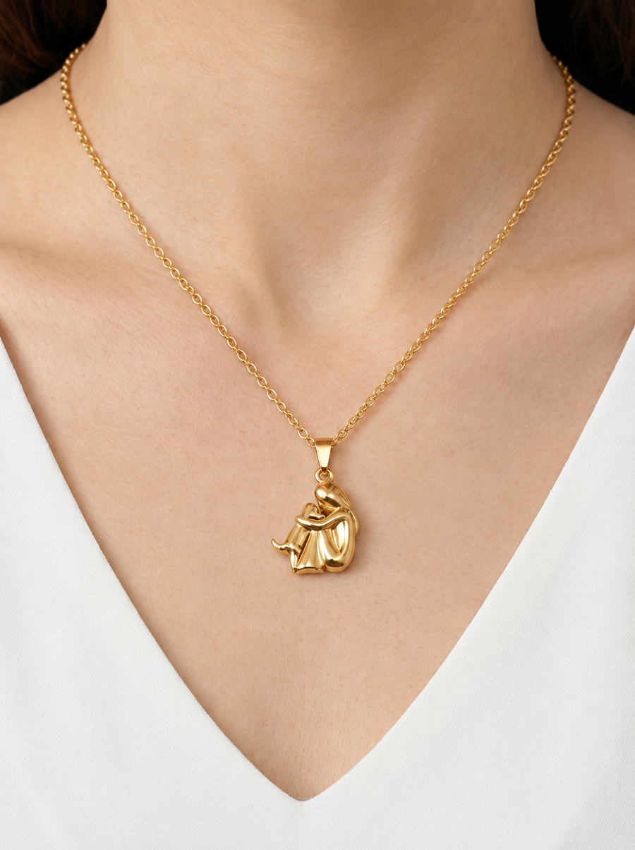 Collar dorado delicado con colgante artístico abstracto y acabado brillante, usado al cuello para un look moderno, elegante y sofisticado.