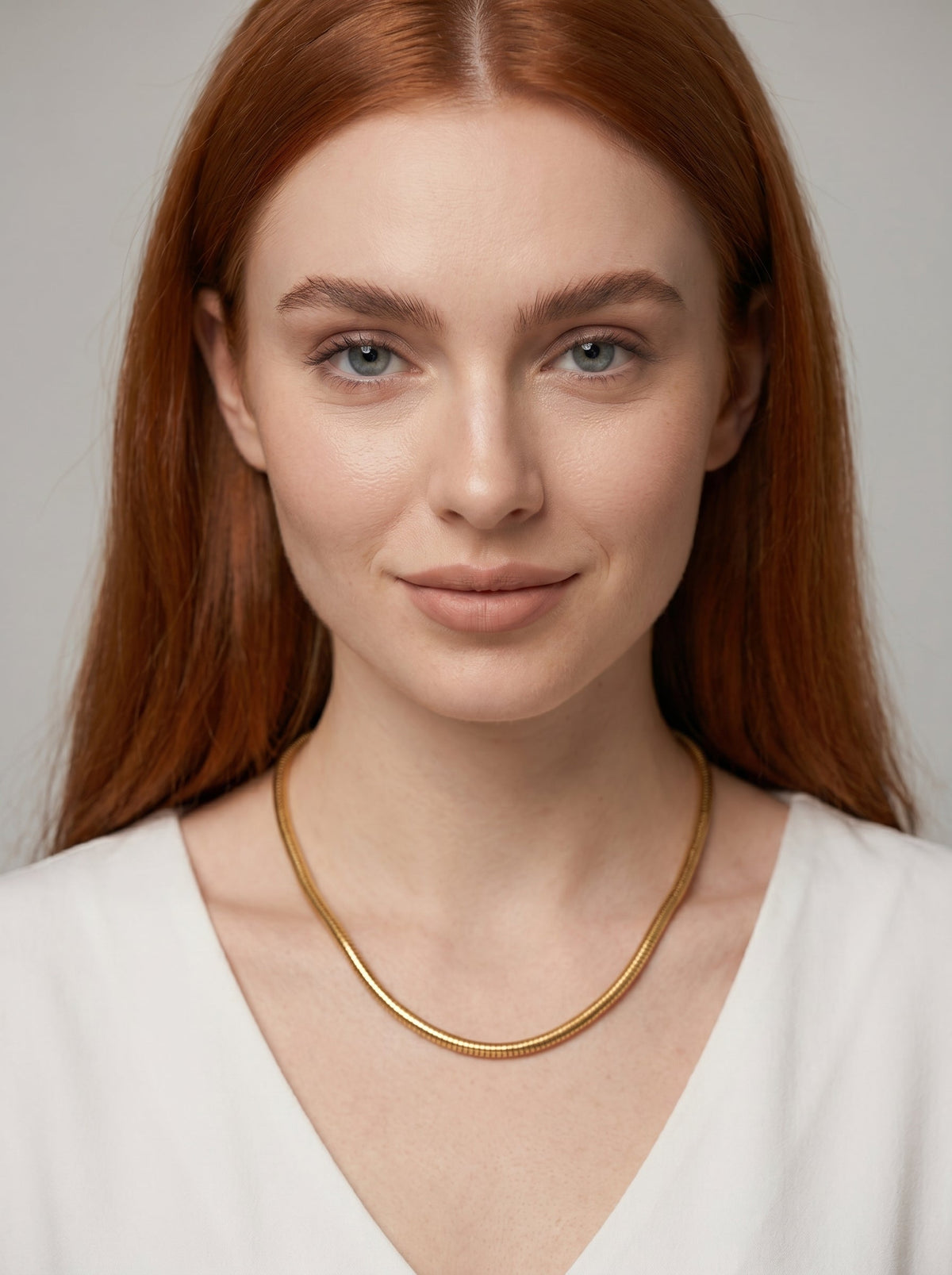 Collar dorado moderno con acabado texturizado y diseño minimalista, llevado por una modelo para un look elegante, artístico y sofisticado.