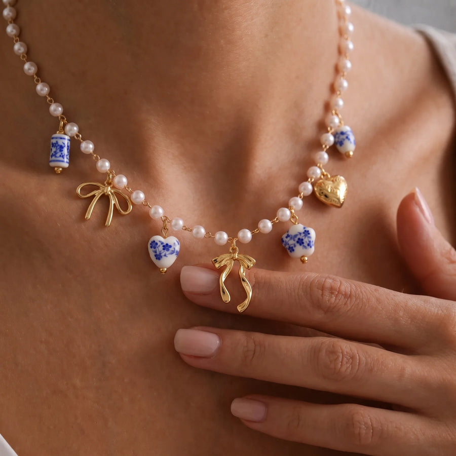 Collar de perlas con lazos y cerámica española en uso sobre el pecho