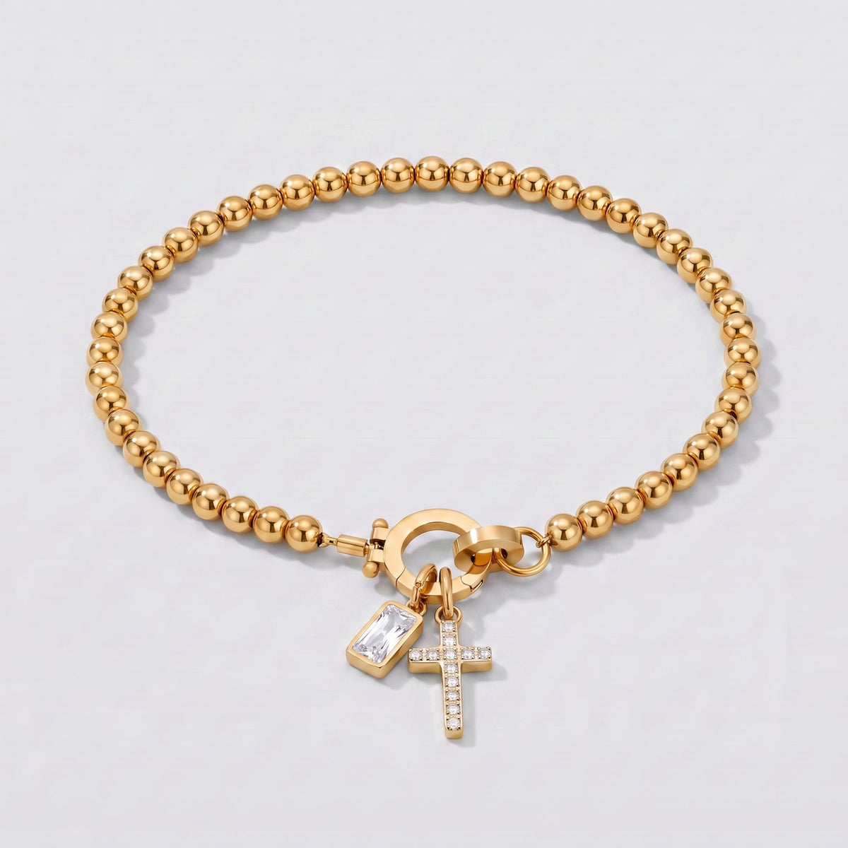 Pulsera dorada de cuentas con cruz y piedra de nacimiento diamante transparente de abril.