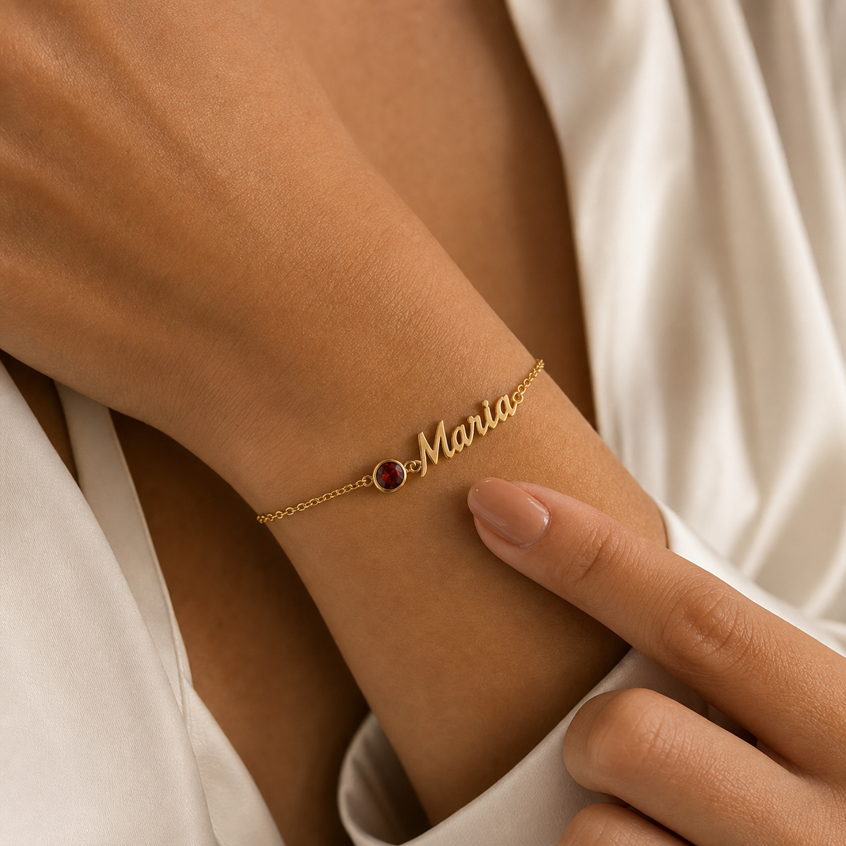 Pulsera con nombre y piedra de nacimiento dorada — Granate (Enero), nombre Maria en la muñeca